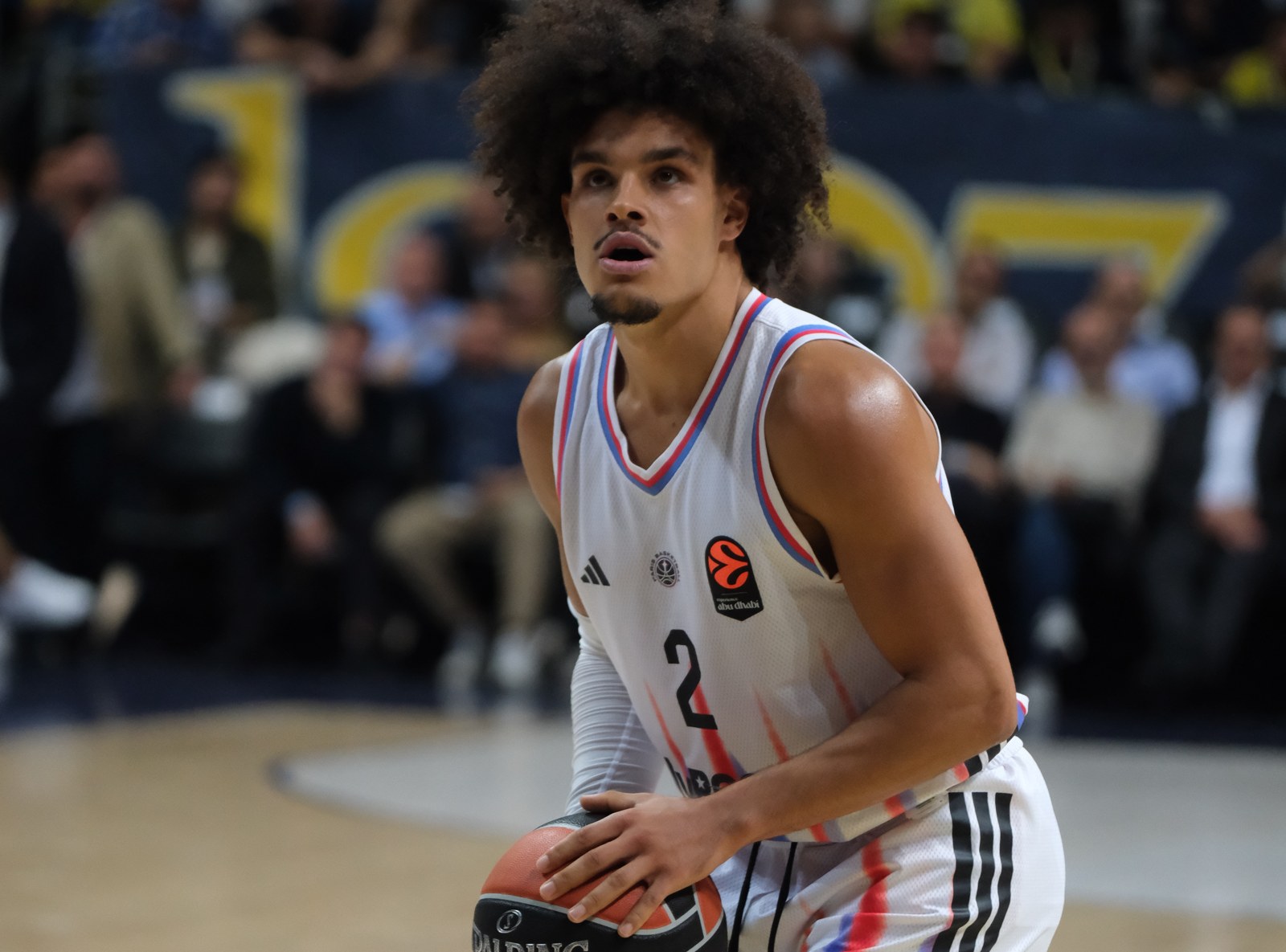 Nadir Hifi of Paris Basketball in his white Paris game jersey, holding the ball in play