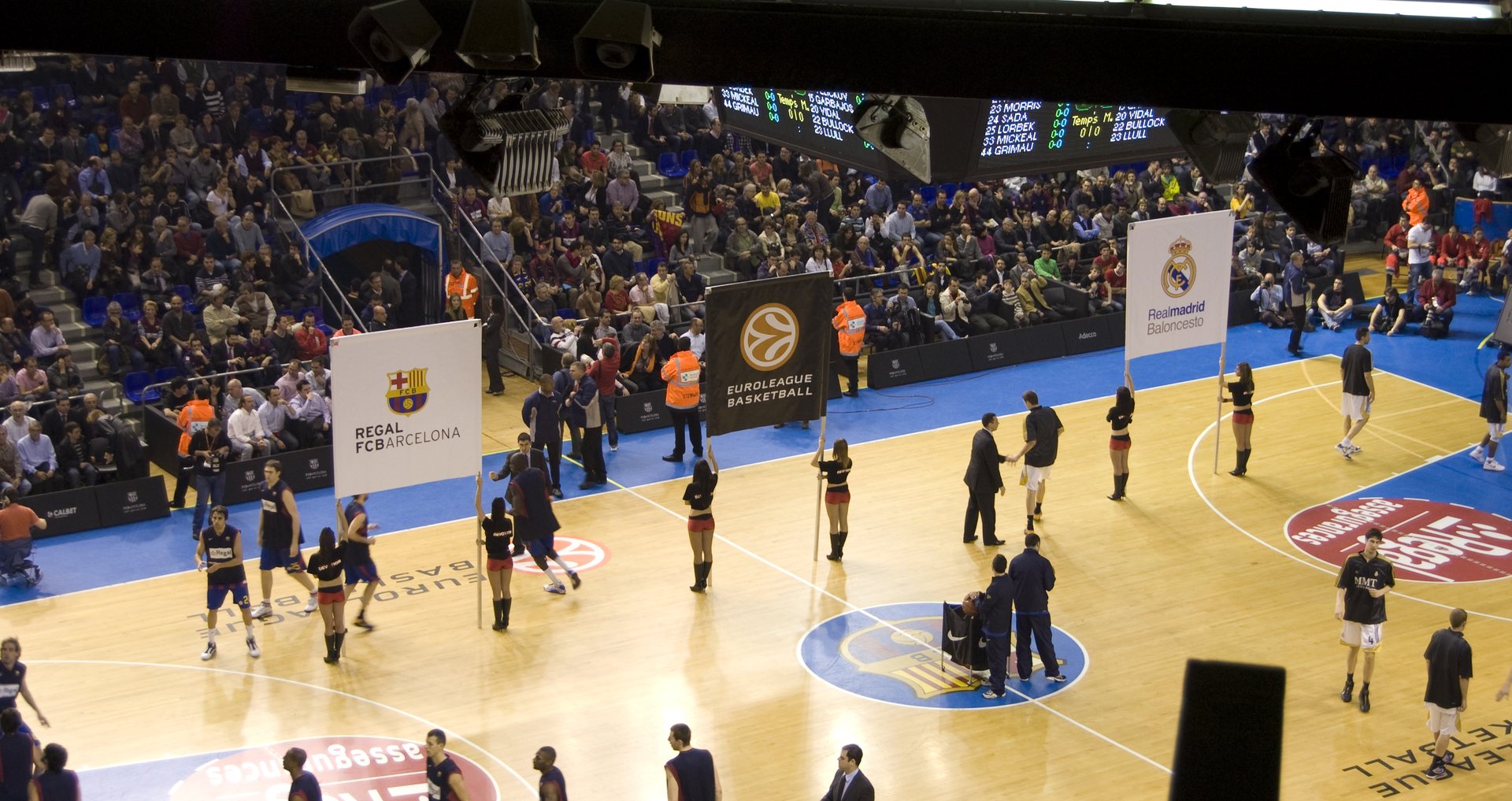 Inside Palau Blaugrana in Barcelona during a EuroLeague game, the basketball court and a packed crowd