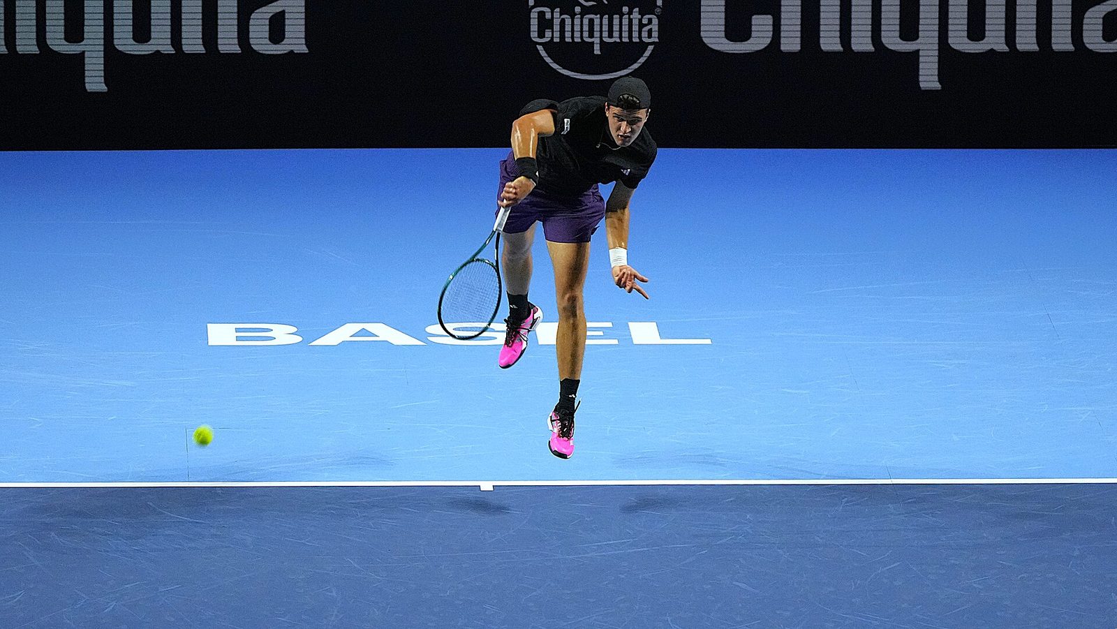 Jakub Mensik serving on an indoor hard court at Basel