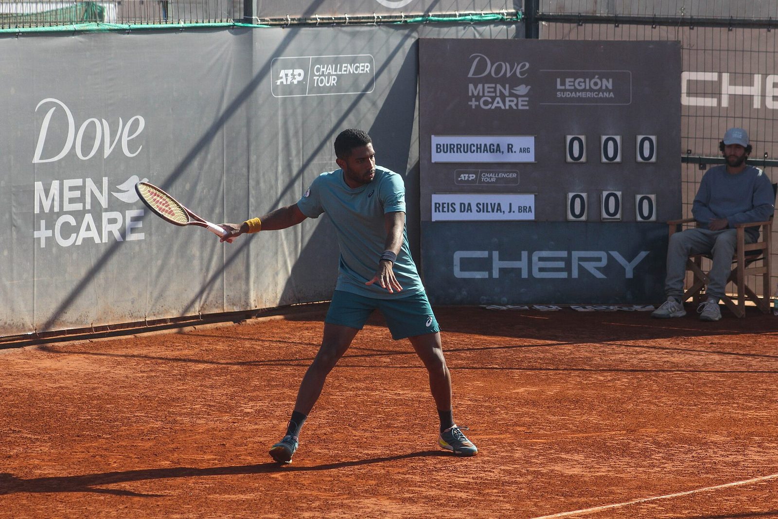 Joao Lucas Reis da Silva hitting a forehand on a clay court at an ATP Challenger event
