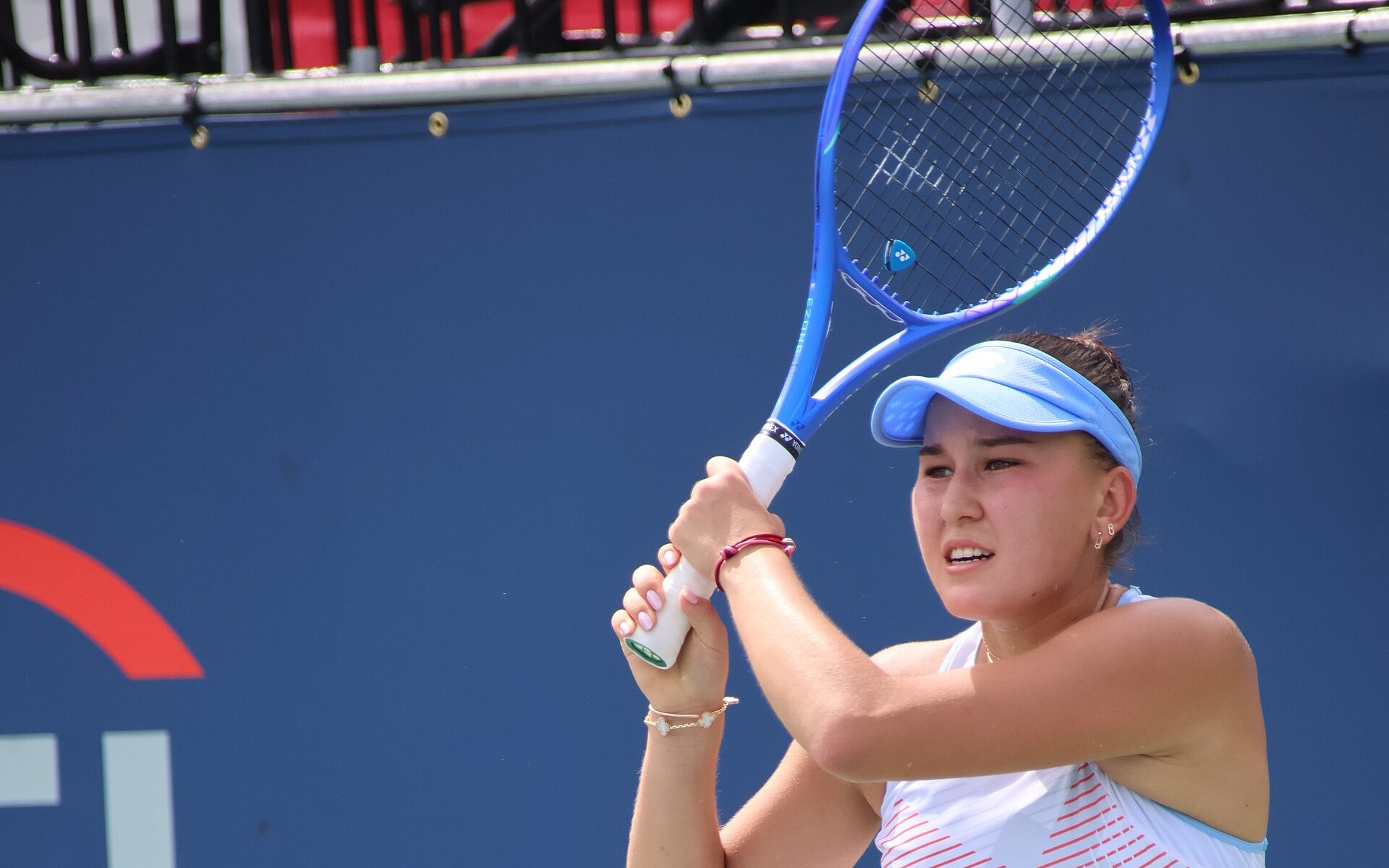Kamilla Rakhimova hitting a two-handed backhand on a hard court in Washington