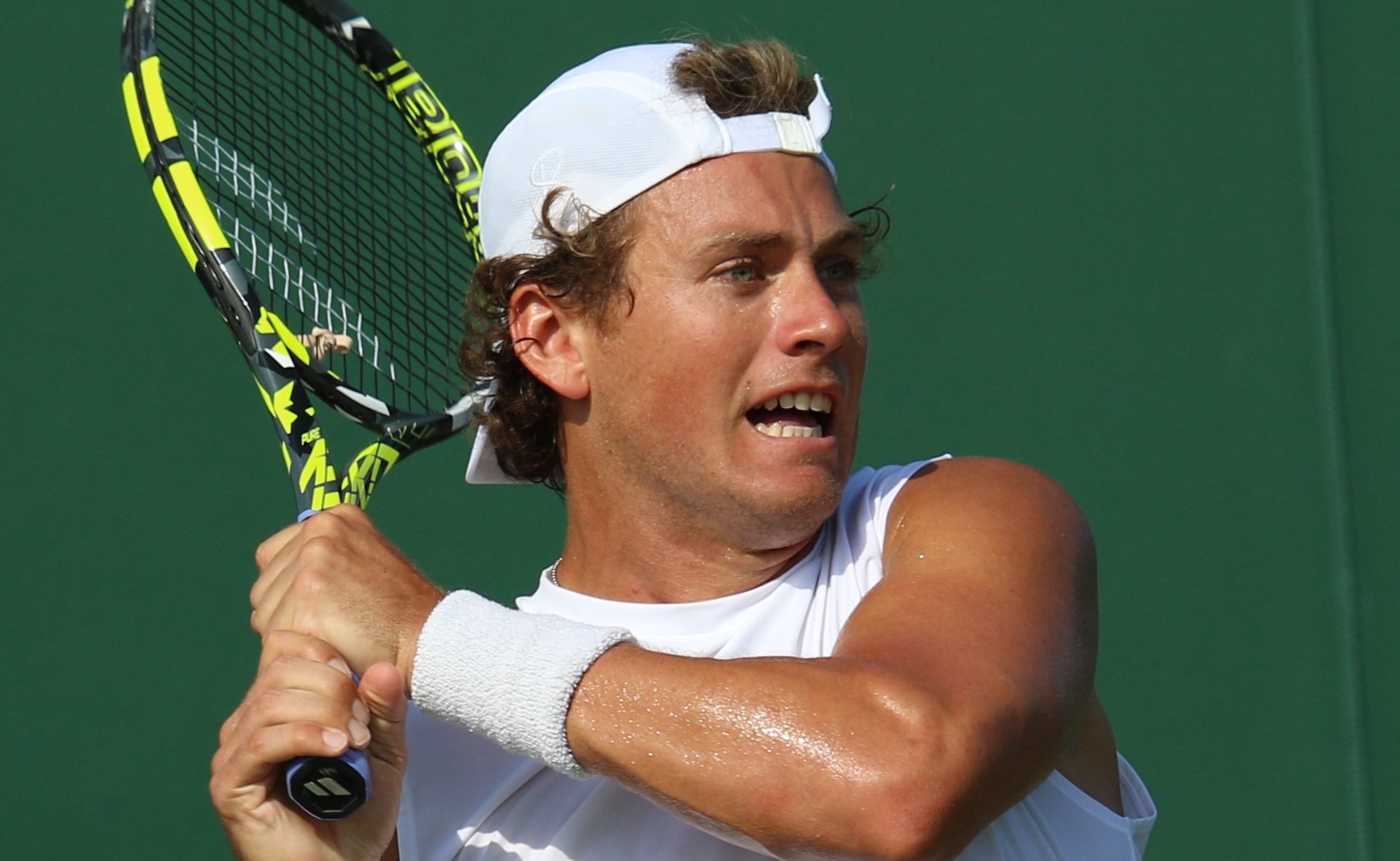 Liam Draxl hitting a two-handed backhand during Wimbledon qualifying