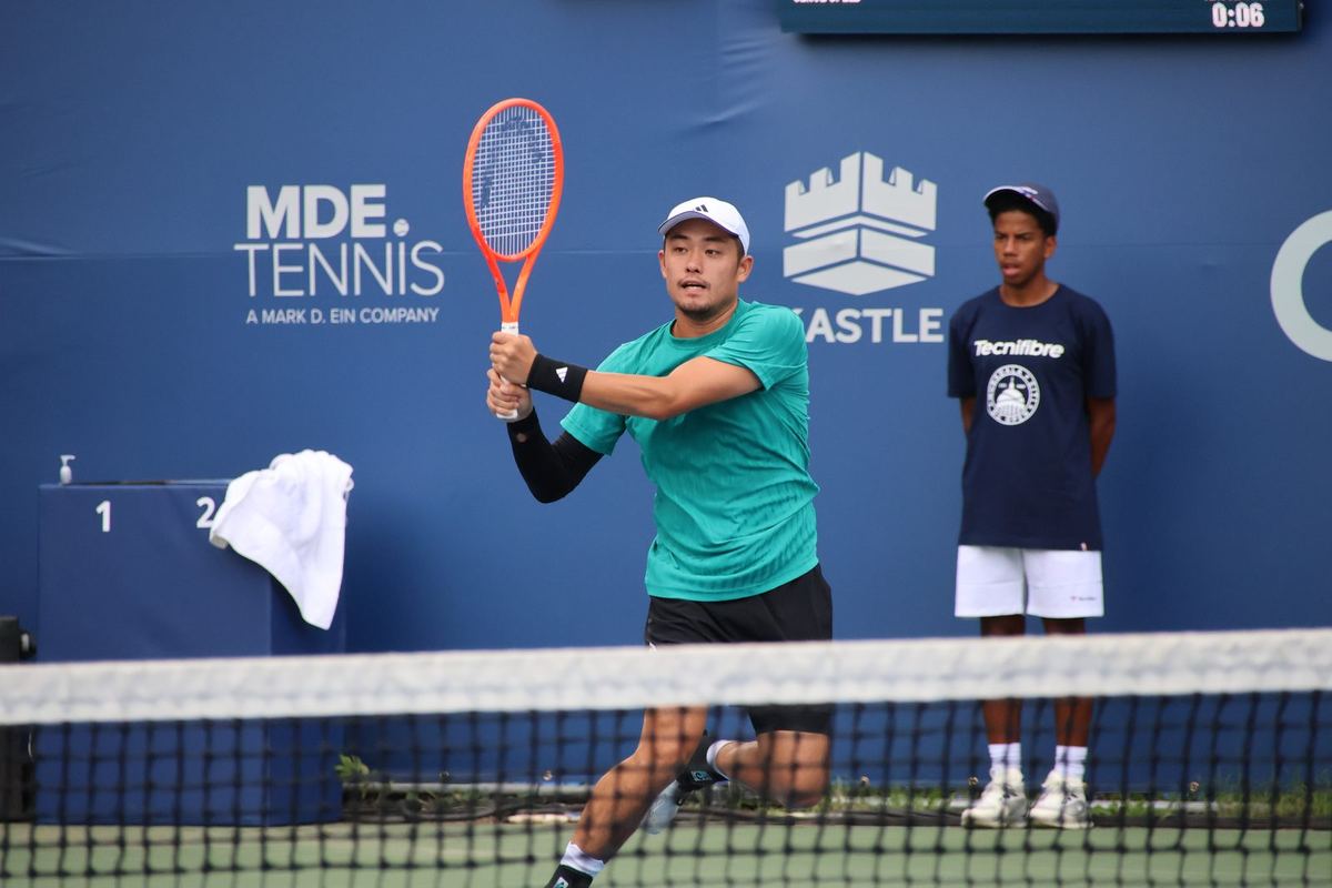 Wu Yibing hitting a two-handed backhand on a hard court in Washington